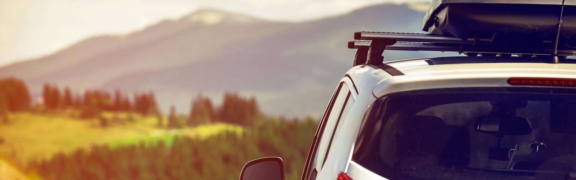 Top left view of a car driving twoards a mountain background