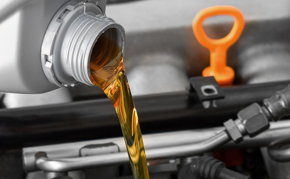 Oil being poured into a car engine.